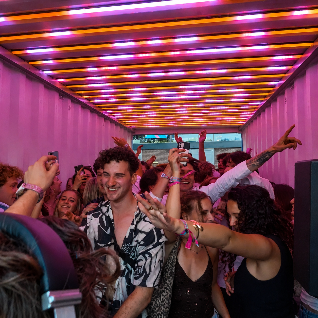 RAVEBOX feestcontainer op studentenfeest Dichtgetikt Tilburg — roze lichtshow met feestende studenten in de mobiele feestcontainer