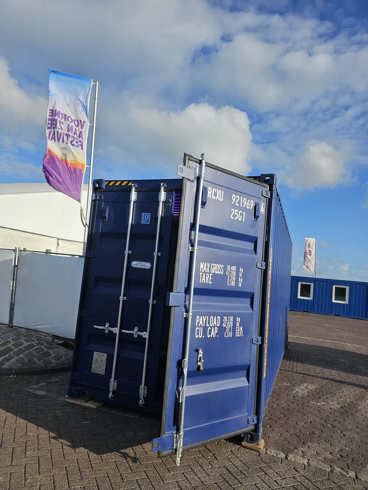 RAVEBOX container stage op het Voorne aan Zee Festival met festivalvlag en geopende containerdeuren